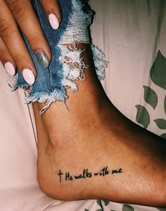 a woman's foot with the words he walks with me tattooed on it