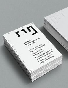 two business cards with the letter t in black and white are stacked on top of each other