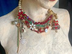 a white mannequin wearing a red and green necklace