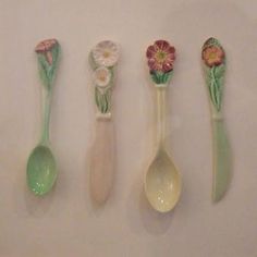 five spoons are lined up in a row with flower designs on the top and bottom