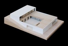 an architectural model of a house on a black background with the top half cut out