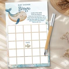 a baby shower game with a dolphin on the cover and a pen next to it