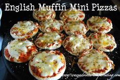 mini pizzas with cheese and tomato sauce are on a black plate, ready to be eaten