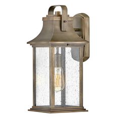 an outdoor wall light with a clear glass shade on the top and bottom part of it