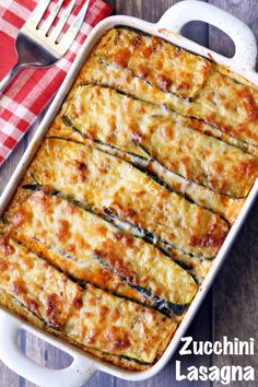 zucchini lasagna in a white casserole dish on a red and white checkered napkin