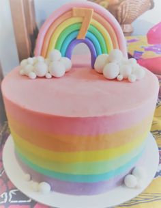 a rainbow cake with white frosting and sprinkles on the bottom layer