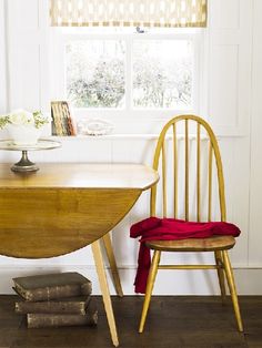 a wooden table and chair in front of a window