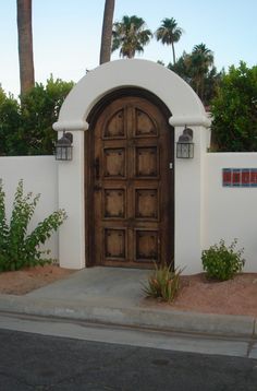 an entrance to a home with palm trees in the background