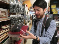 a man is looking at some items in a store while wearing glasses and carrying a backpack