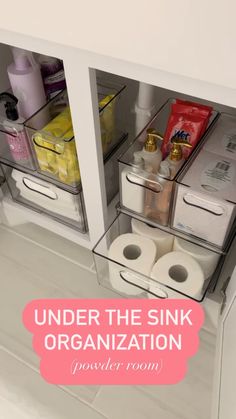 the under the sink organization drawer is organized with clear bins and toilet paper rolls