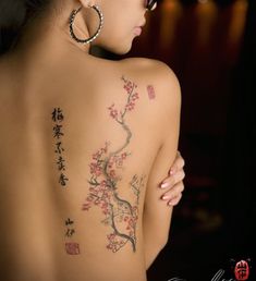 the back of a woman's body with tattoos on it