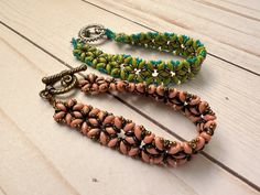 three beaded bracelets sitting on top of a wooden table