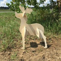 a wooden deer standing in the middle of a field