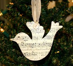 a white bird ornament hanging from a christmas tree with music notes on it