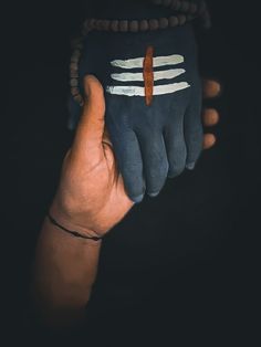 a person's hand with painted fingers holding something