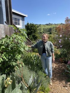 a woman standing in the middle of a garden