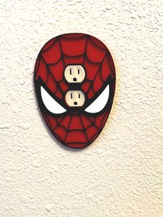 a spider - man face is on the wall with two white eyes and one black eye