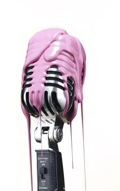 a pink and black object with drips on it's head, in front of a white background