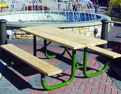 a picnic table with two benches in front of a fountain on a brick patio area