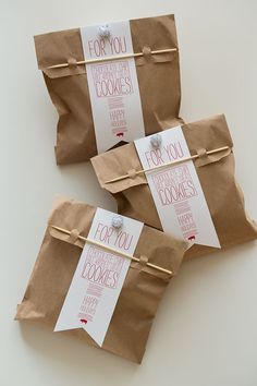 three brown paper bags with tags on them