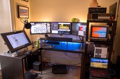 a room with multiple computer monitors and other electronic equipment on the desk in front of it