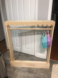 a wooden shelf with clothes hanging on it