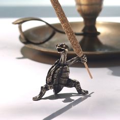 a figurine of a tortoise holding a stick on top of a table