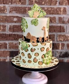 a three tiered cake with an elephant and giraffe design