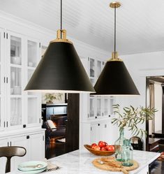 two black lamps hanging over a kitchen island