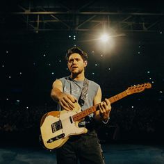 a man playing an electric guitar on stage