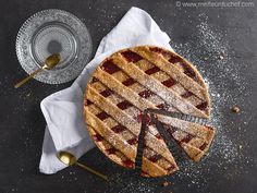 a pie on a table with a slice cut out and two serving utensils next to it