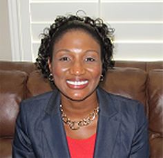 a woman sitting on top of a brown couch wearing a blue jacket and red shirt