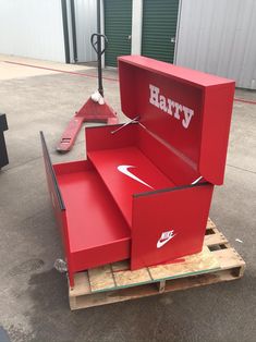 a red box sitting on top of a pallet with the word harry painted on it