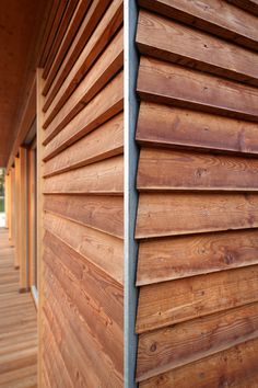 the side of a wooden building with wood slats on it's sides and bottom