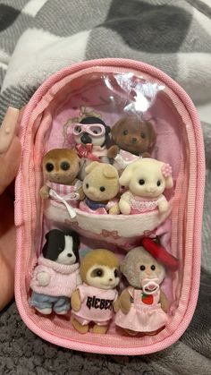 a pink case filled with small stuffed animals