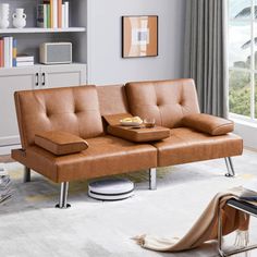 a living room with a couch, coffee table and bookshelf on the wall