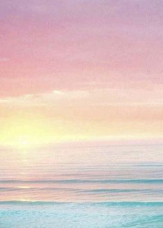 the sky is pink, blue and yellow over the ocean