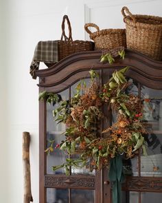 a wreath on top of a china cabinet