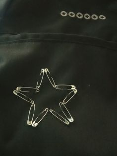 a star shaped object is attached to a black jacket with metal clips on the back