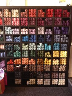 a display case filled with lots of different colored yarns