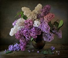 a vase filled with lots of purple and white flowers