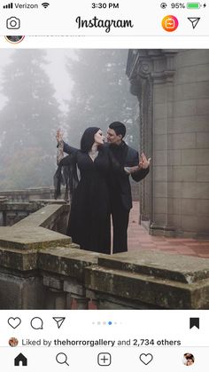 two people standing in front of a stone wall with their arms around each other and one person holding an umbrella