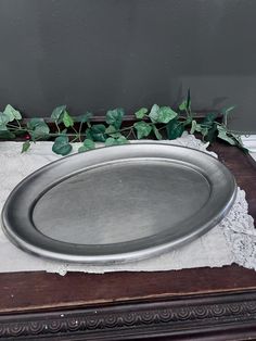 a metal tray sitting on top of a wooden table next to a green leafy plant