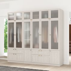 a large white cabinet with glass doors and drawers in the middle of a living room