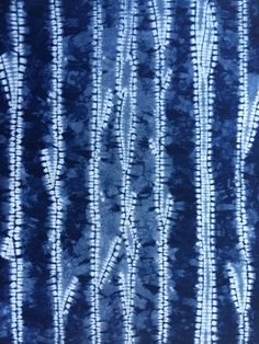 blue and white tie - dyed fabric with vertical lines in the center, all on one side