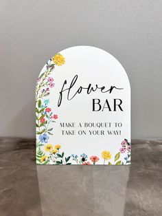 a flower bar sign sitting on top of a table