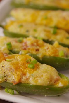 some green peppers with cheese on them are sitting on a white plate and ready to be eaten