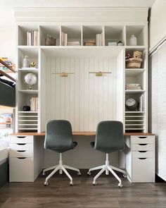 two chairs sit in front of a desk with bookshelves and shelves on it