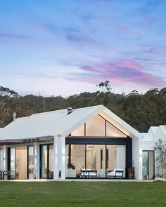 a white house sitting on top of a lush green field