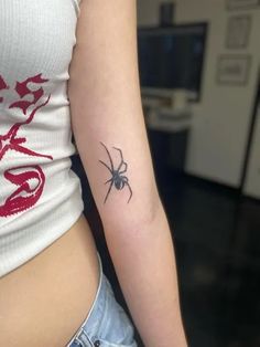 a woman's arm with a tattoo on it that has a spider on it